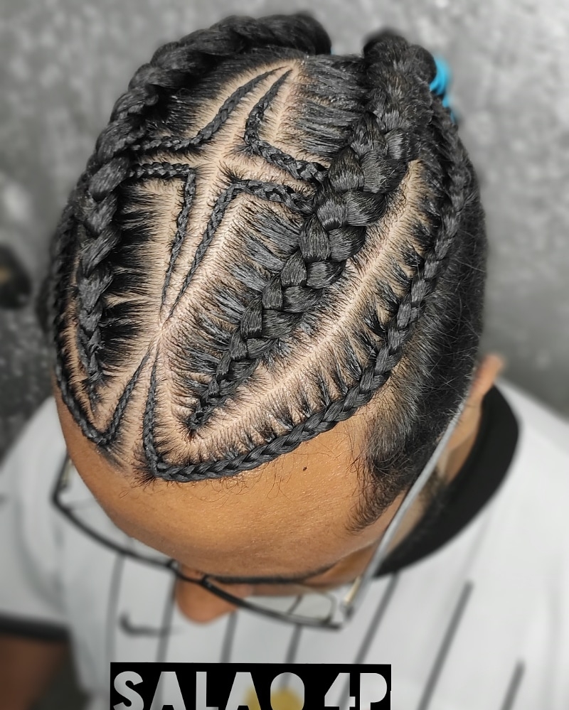 A close-up overhead view of a person's head with intricate braided hairstyles.