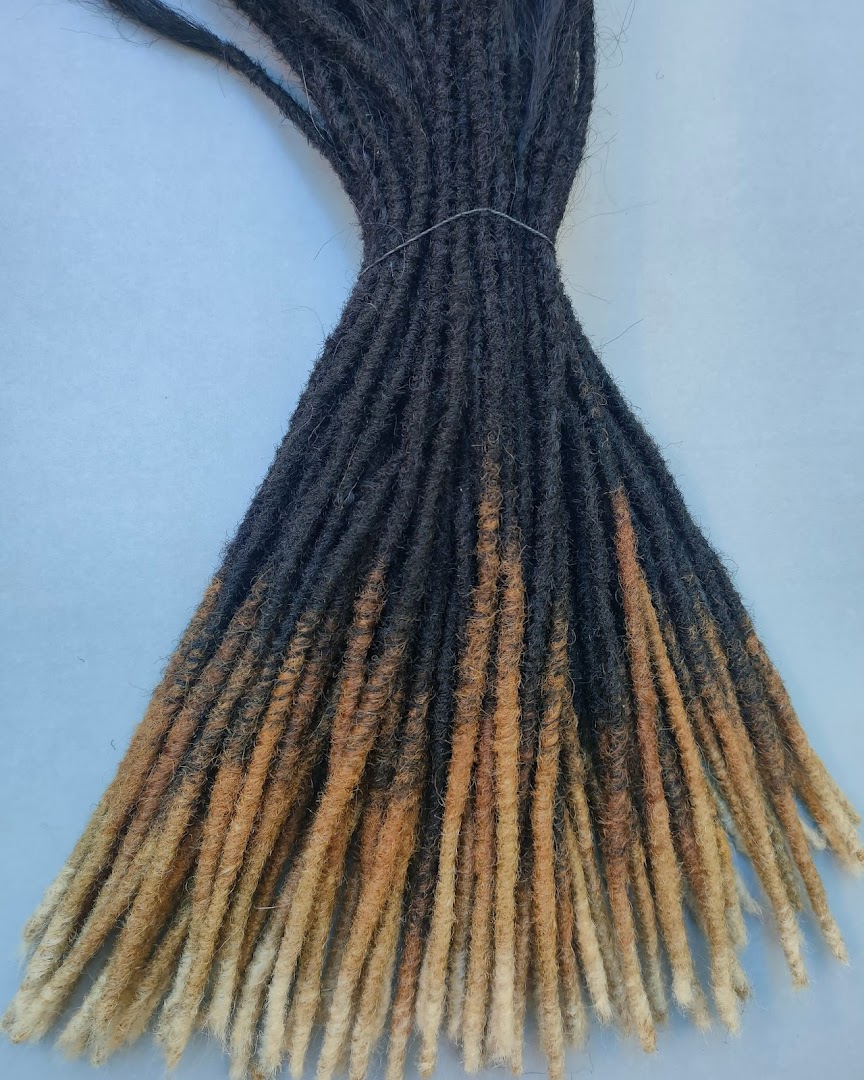 A bundle of dreadlocks with a black to blonde ombre effect, tied together.