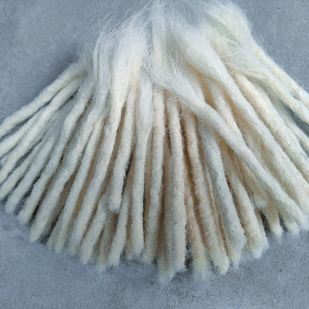 A close-up view of a bundle of white synthetic dreadlocks arranged in a fan shape.