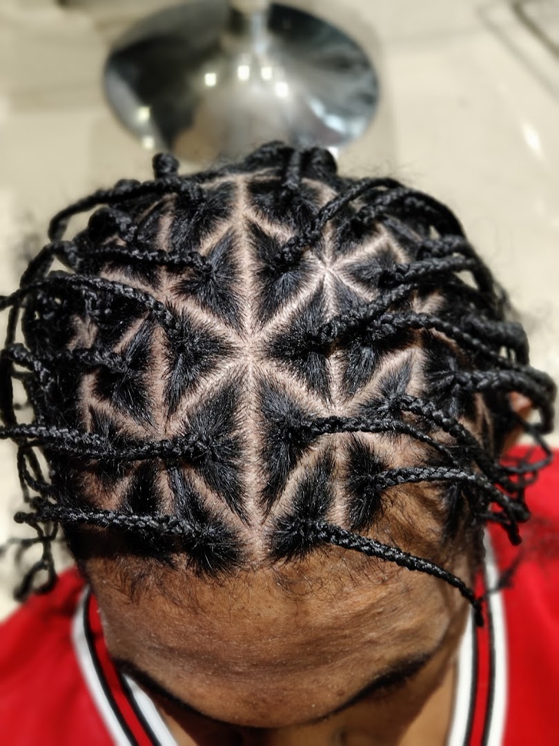 Close-up of intricate braided hairstyle with geometric patterns on a person's head.
