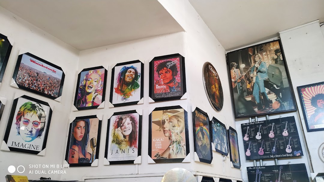 Aqualung Records shop interior with framed posters of musicians and guitars.