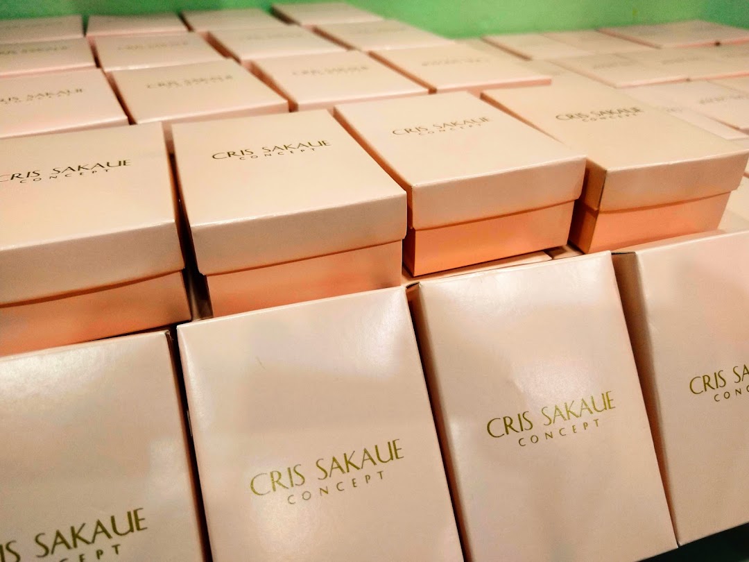 Rows of neatly stacked pink boxes with gold lettering 'CRIS SAKAUE CONCEPT'.