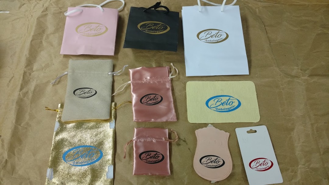 Various branded packaging items including paper bags, pouches, and cards from Beto Embalagens.
