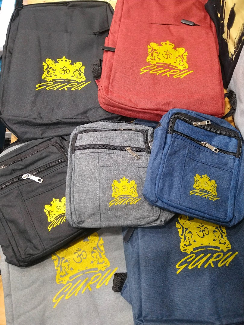 A collection of backpacks and bags in various colors, all featuring a yellow 'GURU' logo.