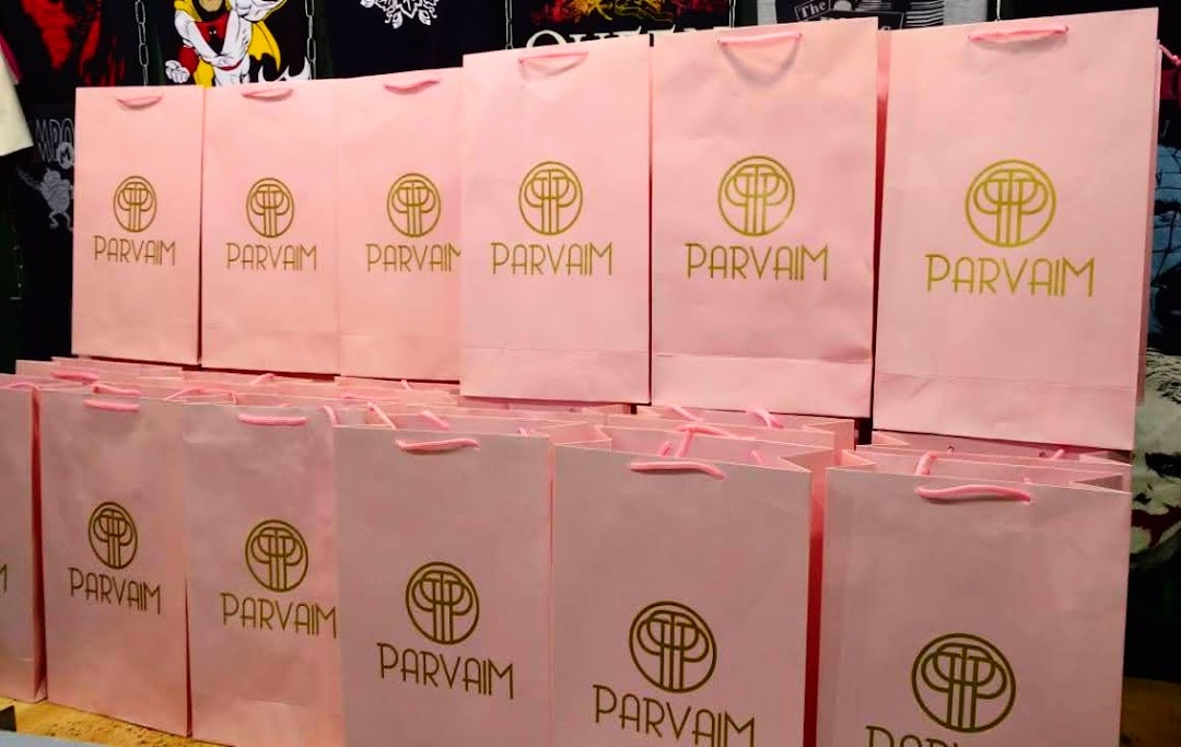 Rows of pink shopping bags with the 'PARVAM' logo are displayed.