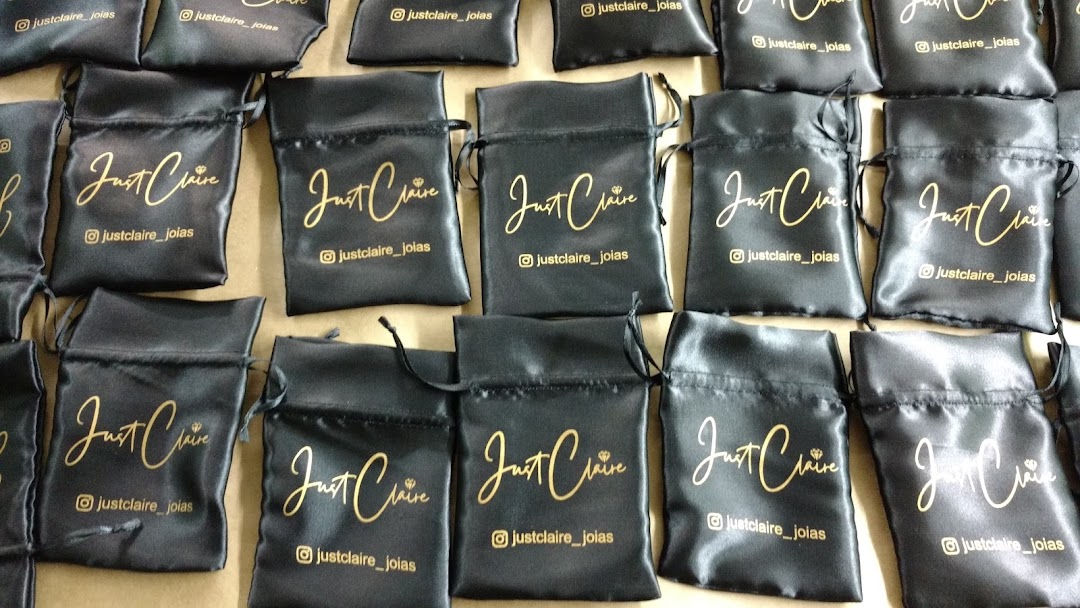 A collection of black satin pouches with gold lettering and Instagram handle.