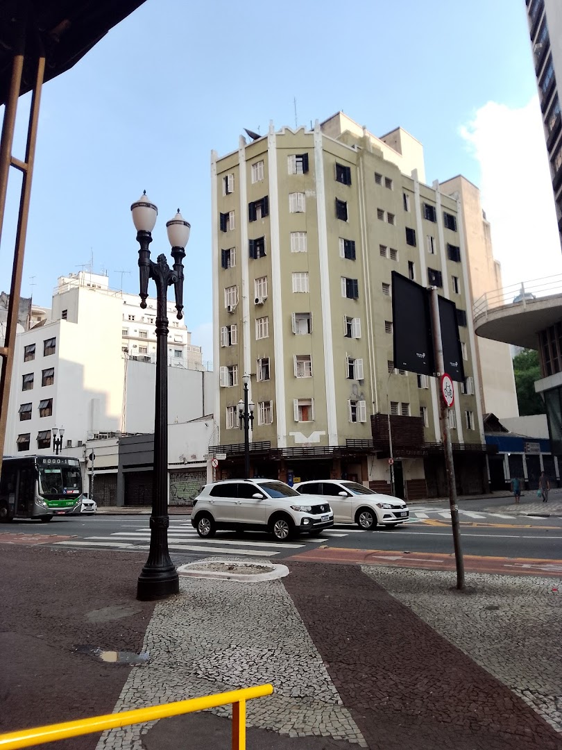 Street view of Avenida São João with buildings, cars, and a bus on a clear day.