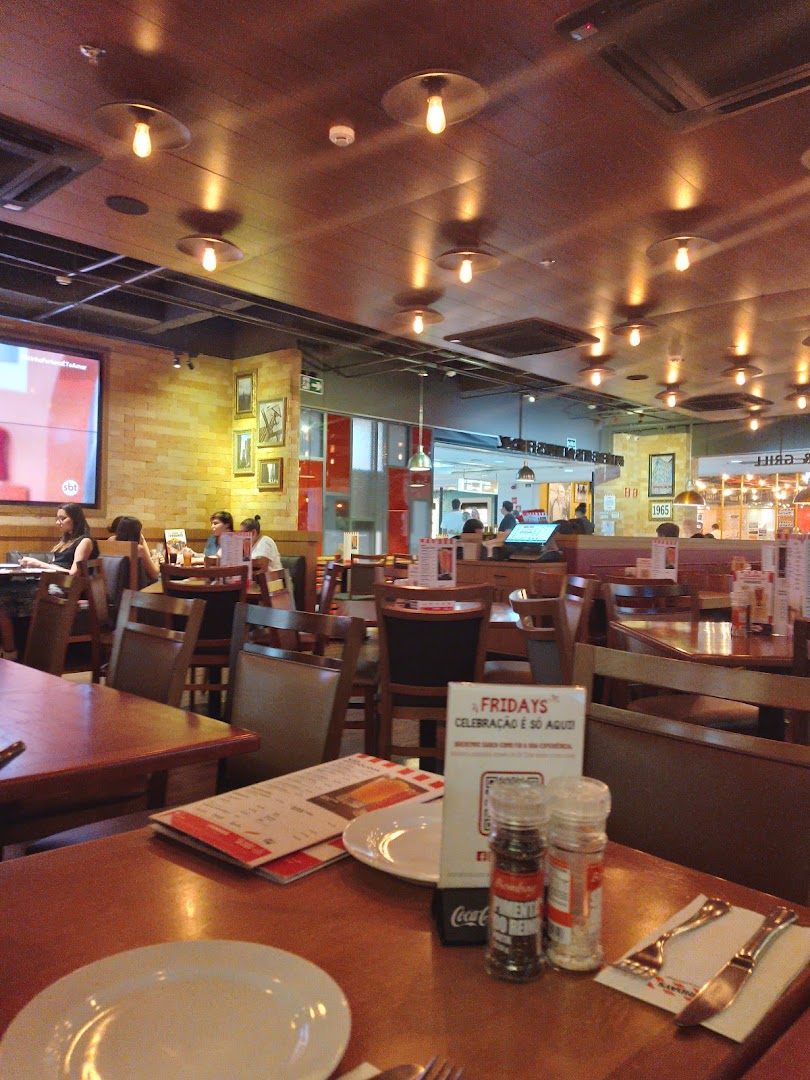 Interior view of a busy restaurant with tables, chairs, and people dining.