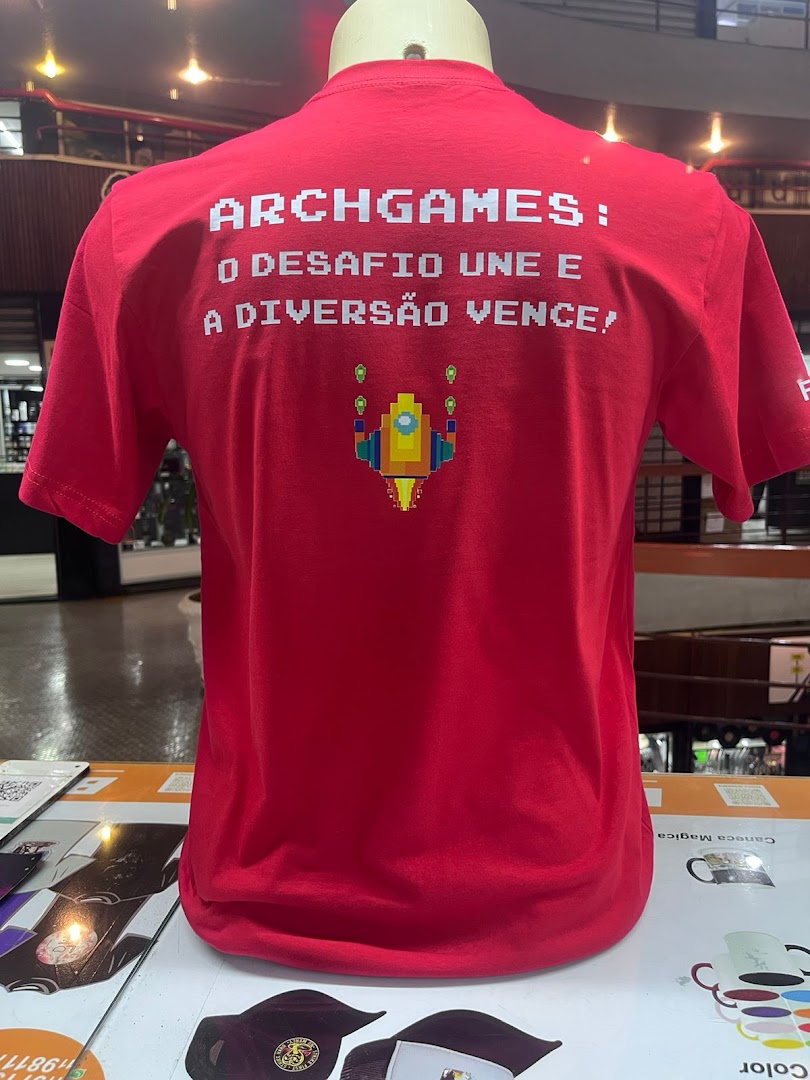 A red t-shirt with pixelated text and a rocket graphic is displayed on a mannequin.