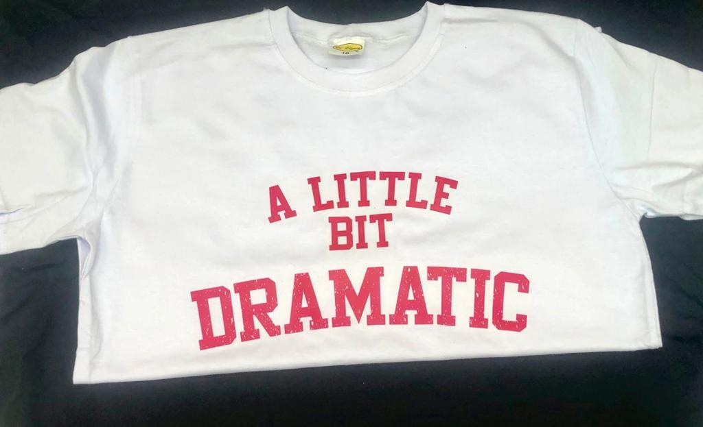 A white t-shirt with red text that reads 'A LITTLE BIT DRAMATIC'.