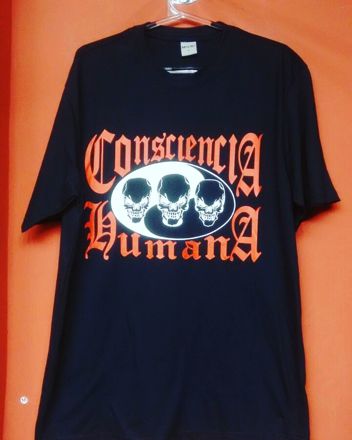 A black t-shirt with an orange graphic featuring three skulls and text.