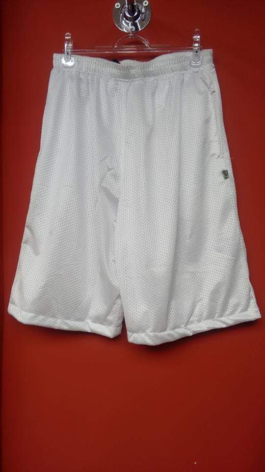 A pair of white mesh athletic shorts hanging on a hanger against a red background.