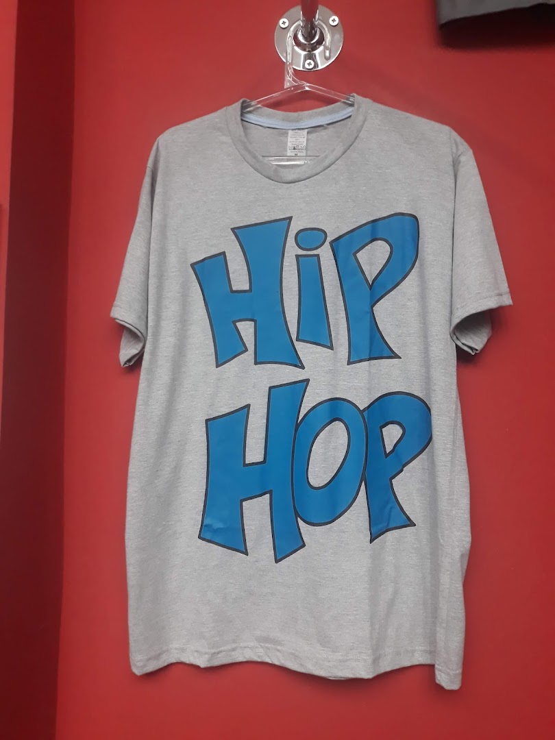 A grey t-shirt with blue 'Hip Hop' text is displayed against a red wall.