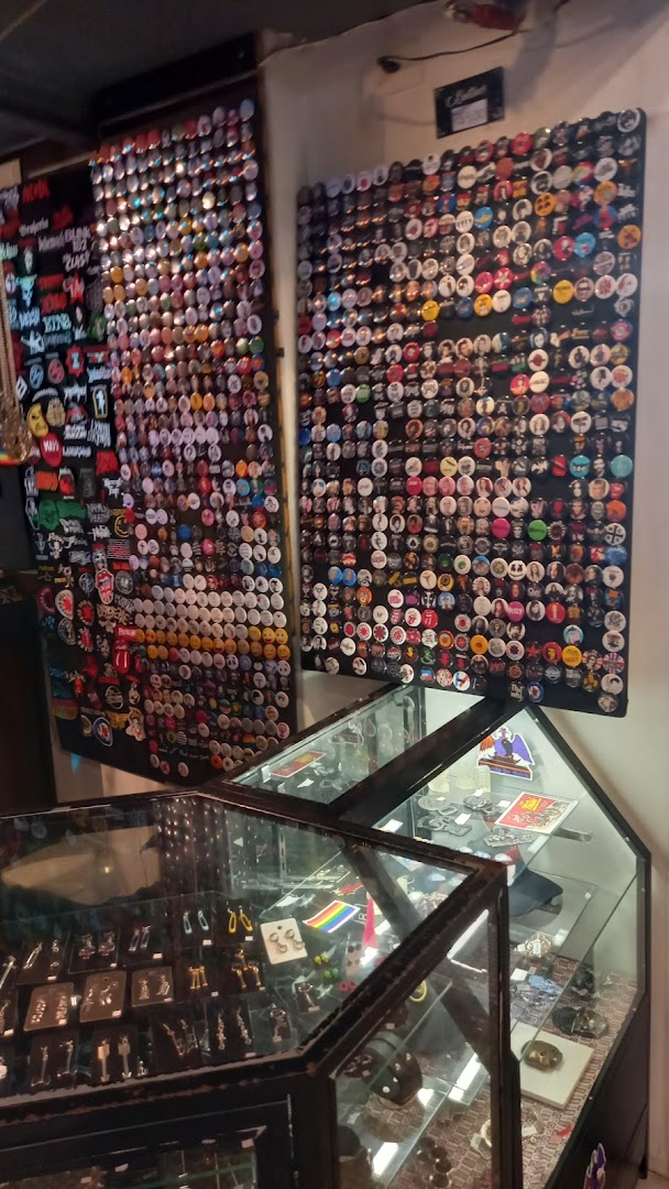Shop interior displaying a vast collection of band pins and accessories in display cases.