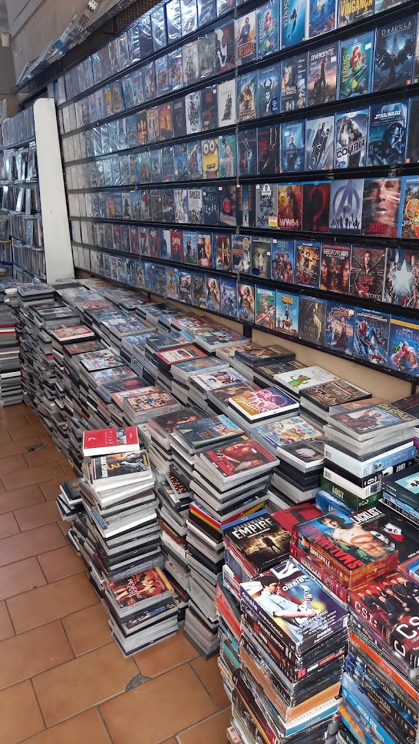 A shop interior filled with shelves and stacks of DVDs and Blu-rays.