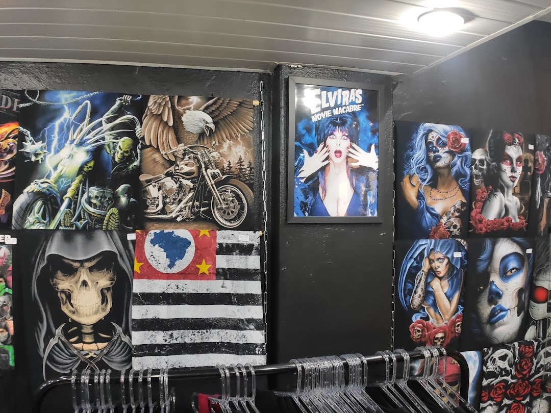 A shop interior displaying various graphic t-shirts and posters with dark, gothic, and biker themes.