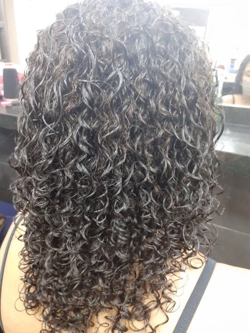 A close-up view of a person's curly, wet hair after a salon treatment.