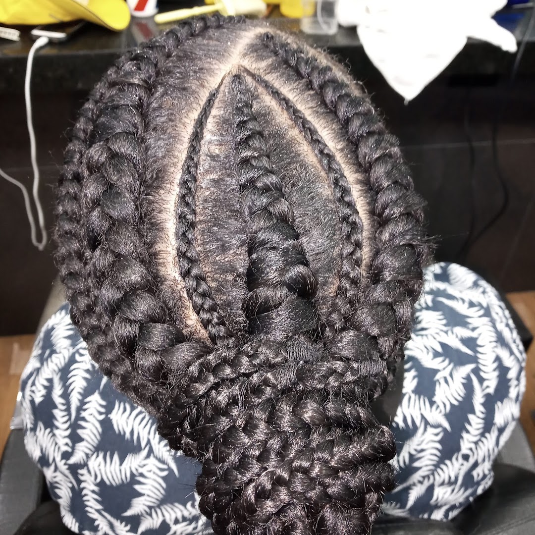A close-up overhead view of a person's head with intricate braided hairstyles.