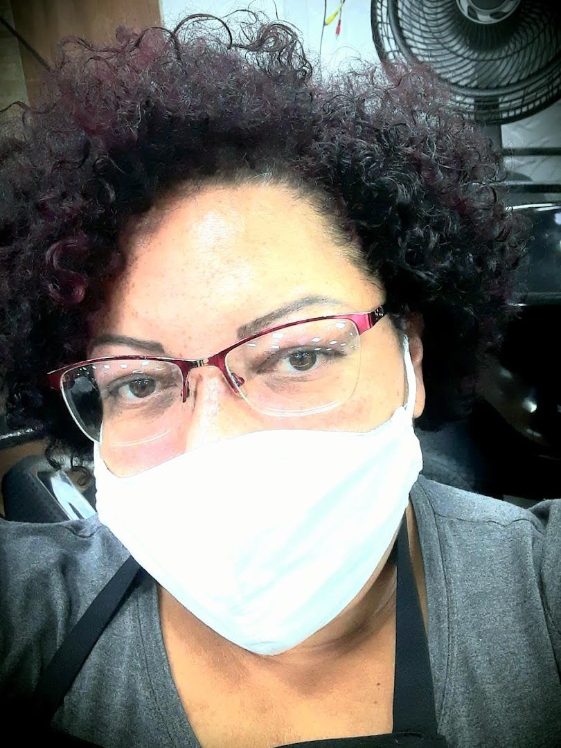 A close-up selfie of a person wearing glasses and a white face mask.