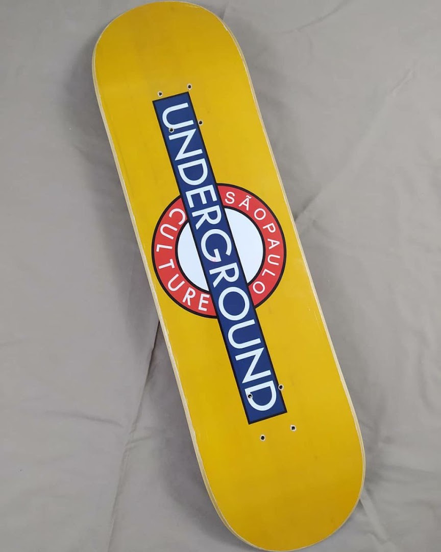 A yellow skateboard deck with a blue and white 'Underground São Paulo Culture' graphic.