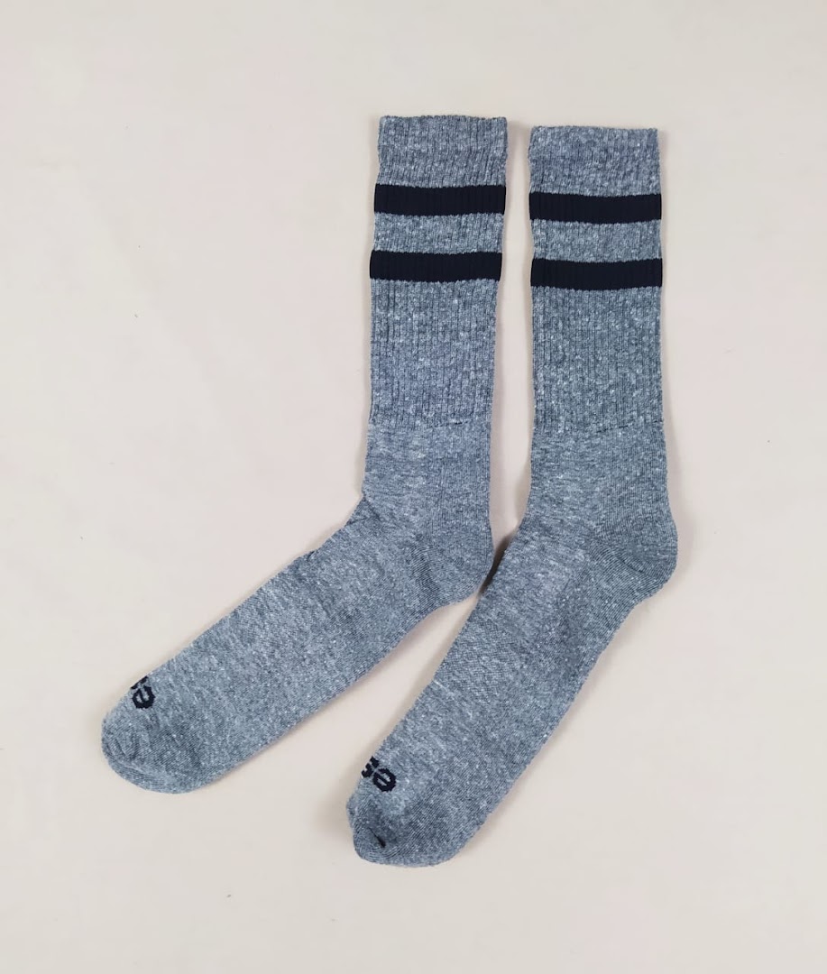 A pair of grey athletic socks with two navy blue stripes near the cuff.