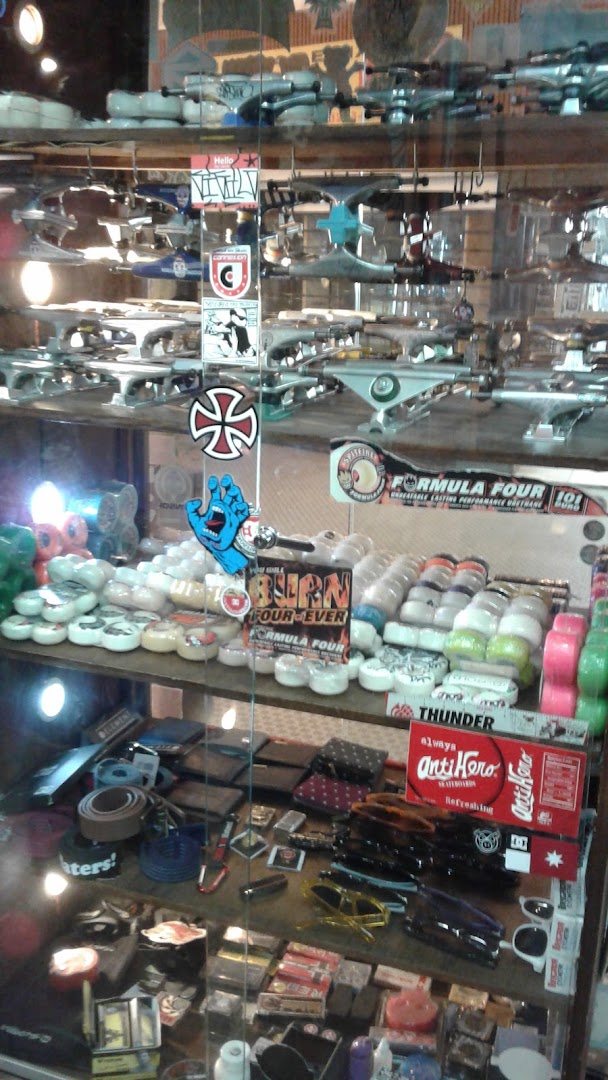 A display case filled with skateboards, wheels, trucks, wallets, and sunglasses.