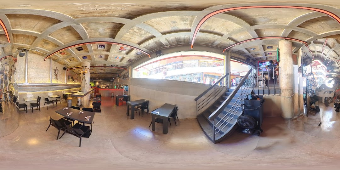 Interior view of Galeria do Rock Bar with tables, chairs, and a stage area.