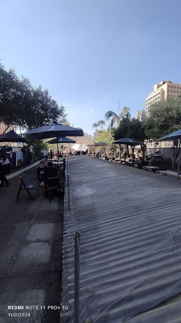 Outdoor seating area with umbrellas and tables at Galeria do Rock Bar.