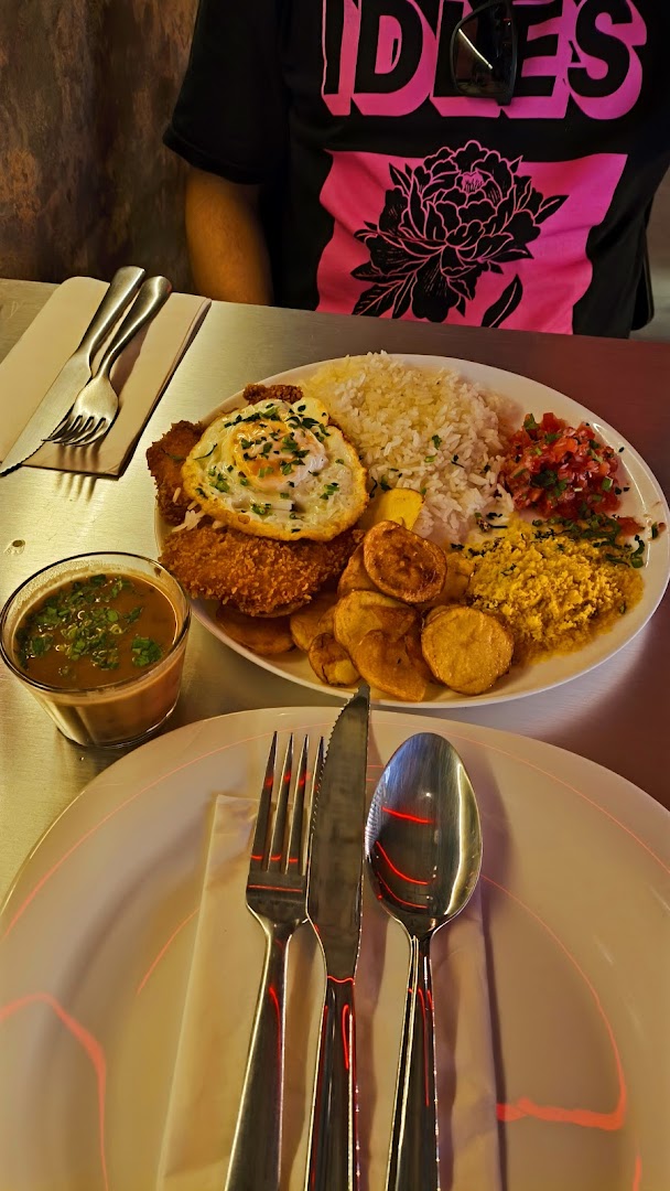 A hearty meal with fried chicken, rice, egg, potatoes, and salad, served with a side of soup.