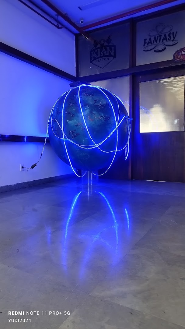 A globe sculpture with blue LED lights and reflections on the floor.