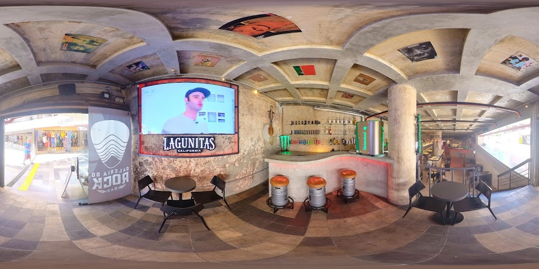 Interior view of Galeria do Rock Bar with a bar, seating, and a large screen.