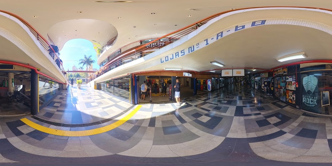 Interior view of a shopping mall with various shops and an open-air atrium.