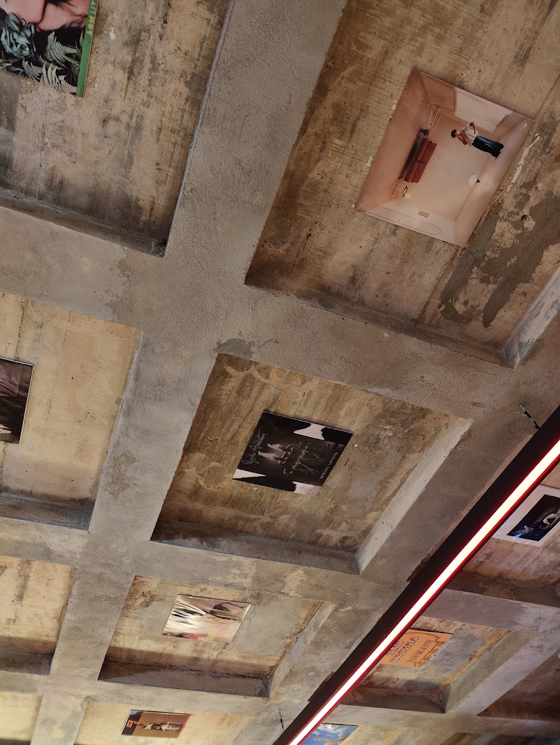 A concrete ceiling with various album covers and artwork displayed in recessed panels.