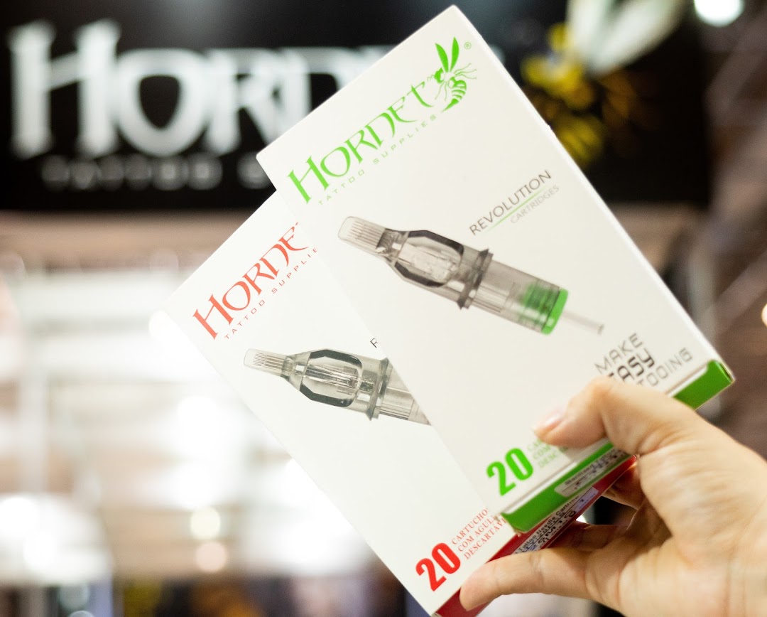 A hand holds boxes of Hordet tattoo cartridges, showcasing tattoo supplies.
