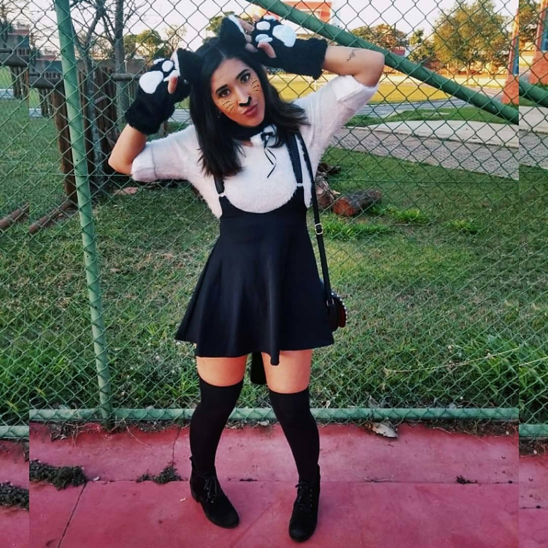 A person dressed in a cat-themed outfit with ears, paws, and face paint.