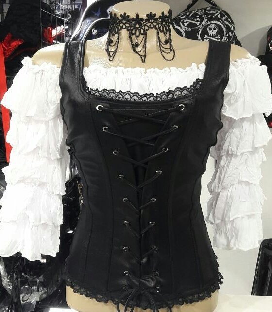 A mannequin displays a black corset with white ruffled sleeves and a black lace choker.