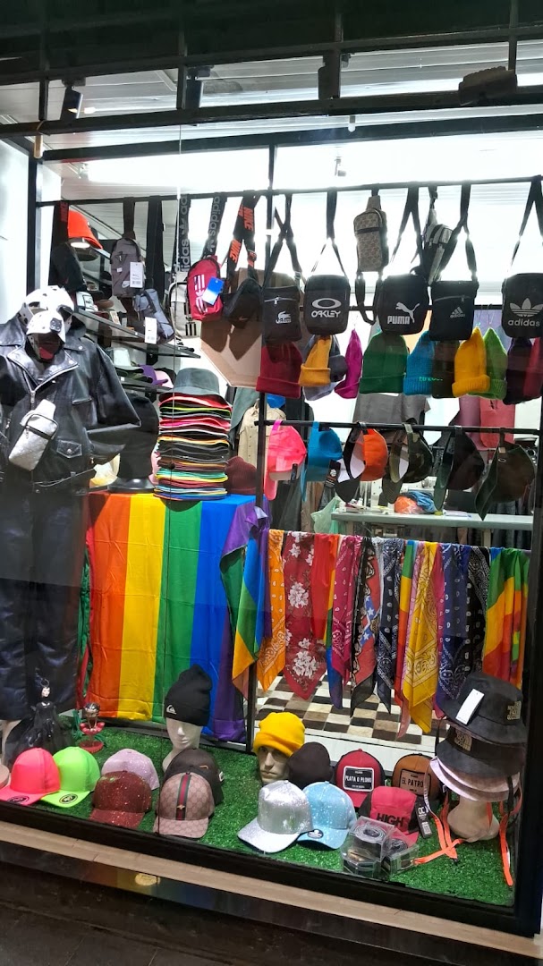 Shop window display featuring a variety of hats, bags, and colorful textiles.