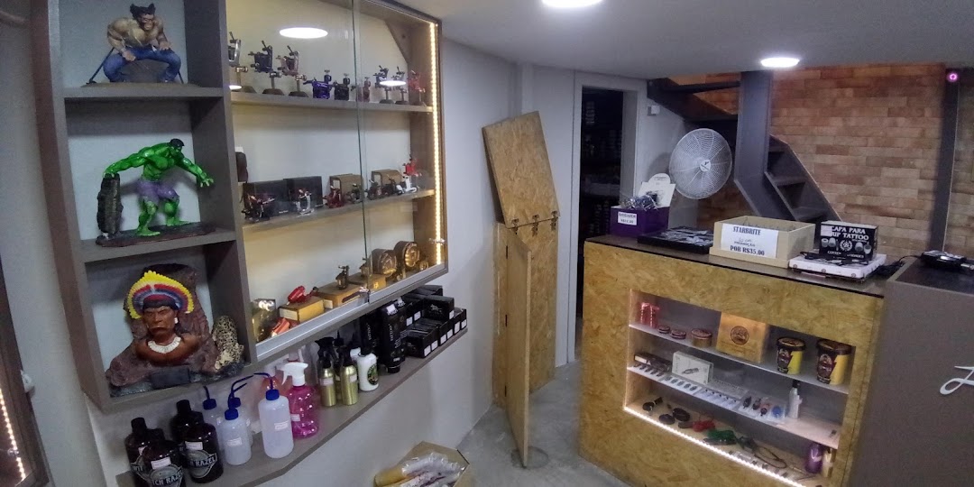 Interior of a tattoo shop with display shelves showcasing tattoo equipment and pop culture figures.
