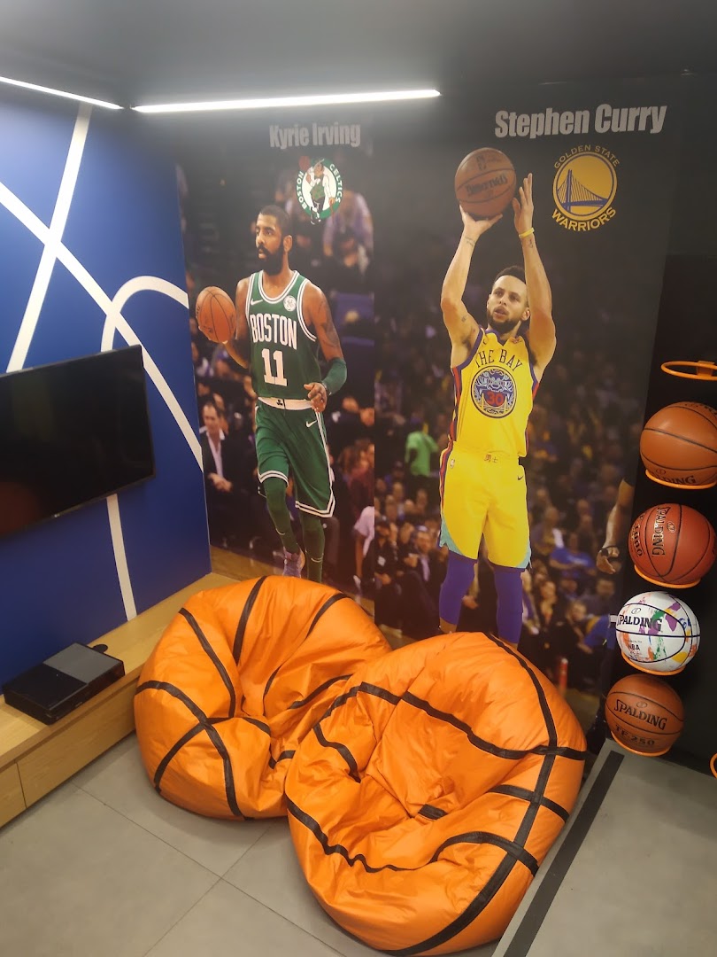 Interior of a sneaker shop with basketball player murals and basketball-themed seating.