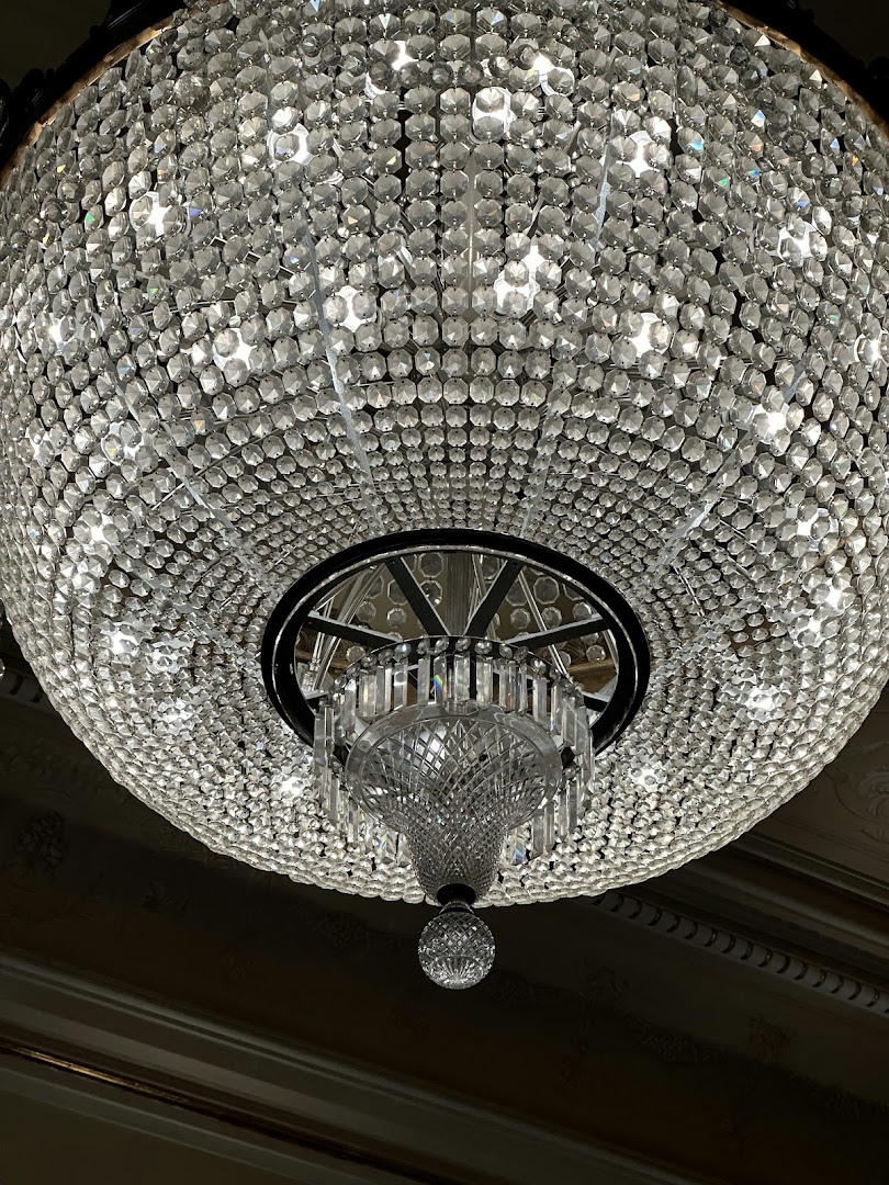 A close-up view of a large, ornate crystal chandelier with many facets reflecting light.