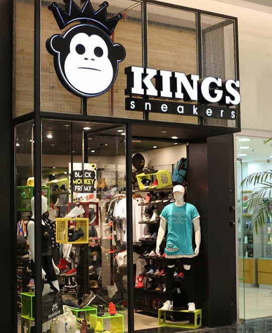 The Kings Sneakers shop front displays a variety of sneakers and apparel with mannequins.
