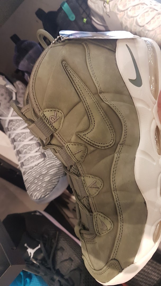 Close-up view of a stylish olive green sneaker with a white sole and Nike logo.