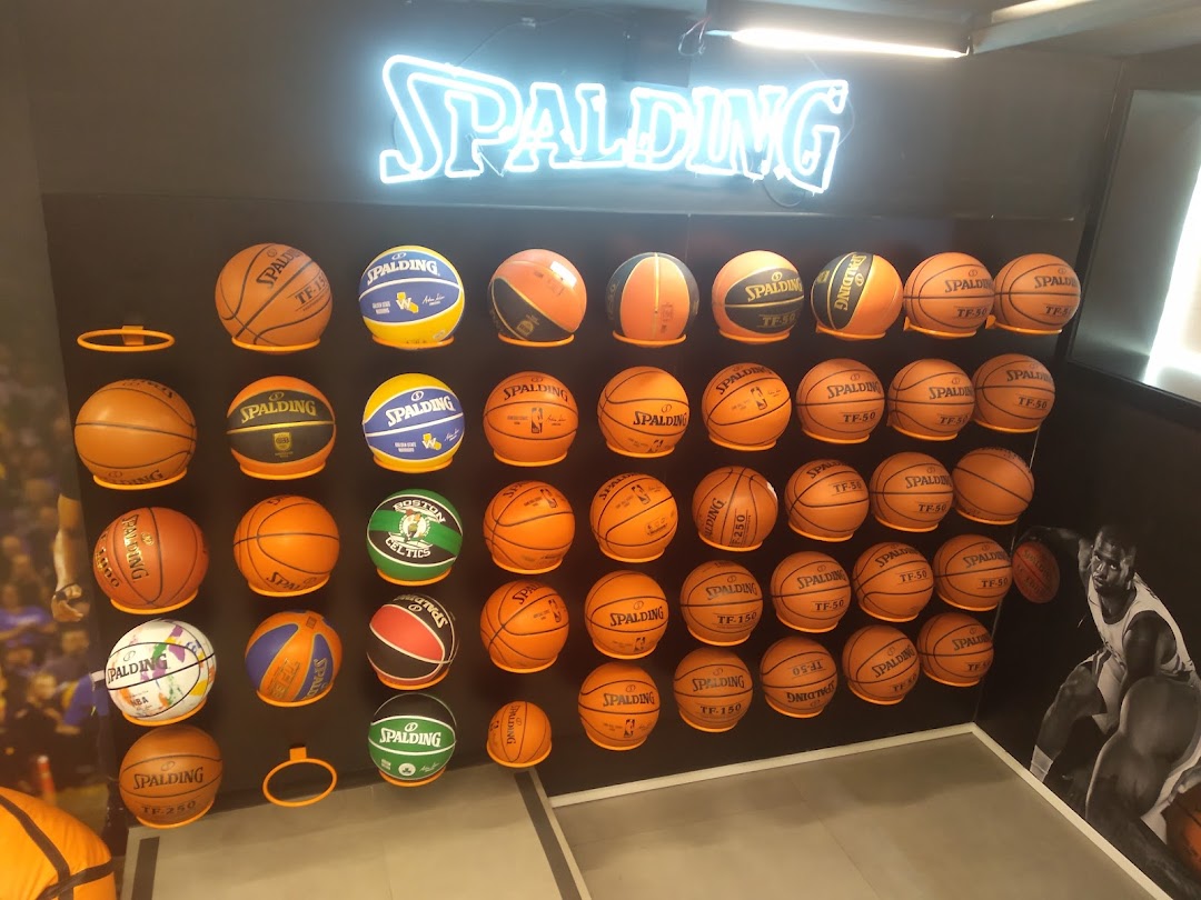 A wall display featuring numerous Spalding basketballs of various designs and sizes.