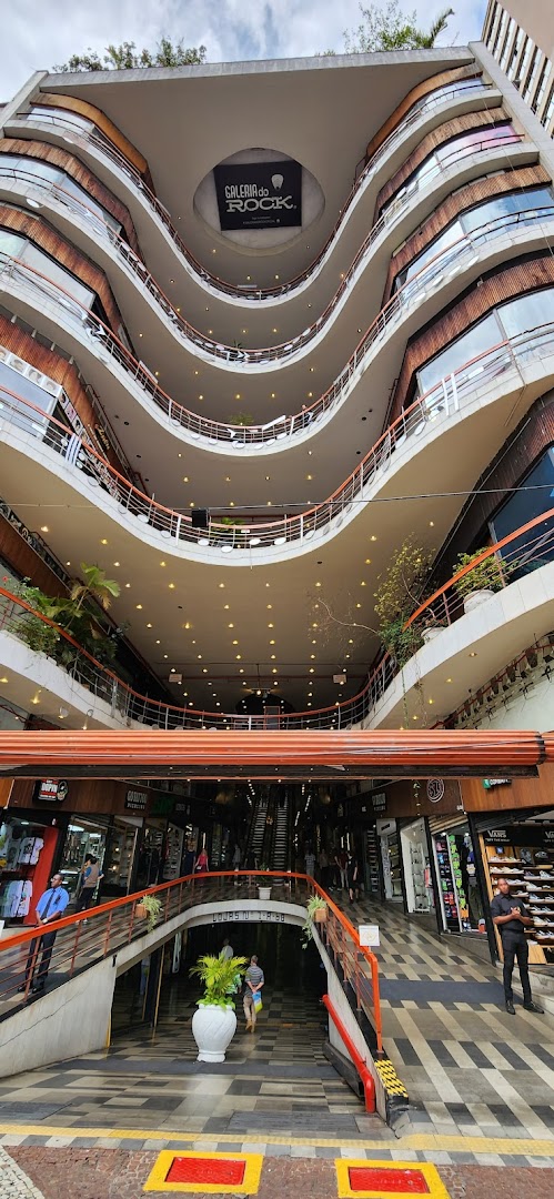 Interior view of a multi-level shopping mall with escalators and various shops visible.