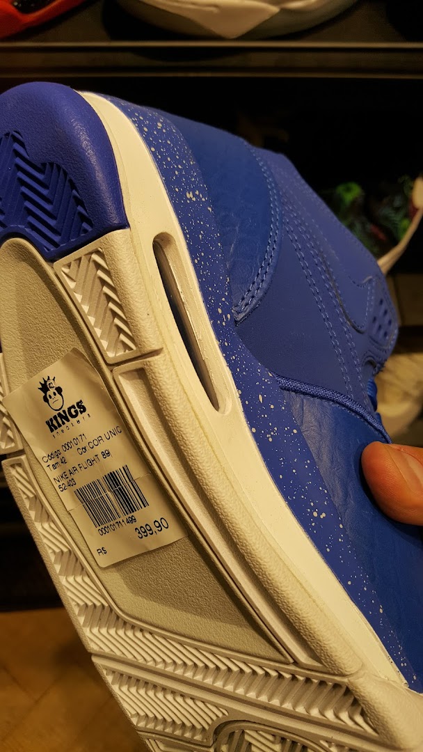 Close-up of a blue Nike Air Flight 89 sneaker with a price tag attached.