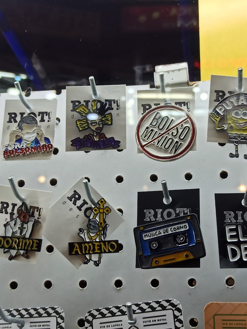 A display of various enamel pins featuring pop culture references and political commentary.
