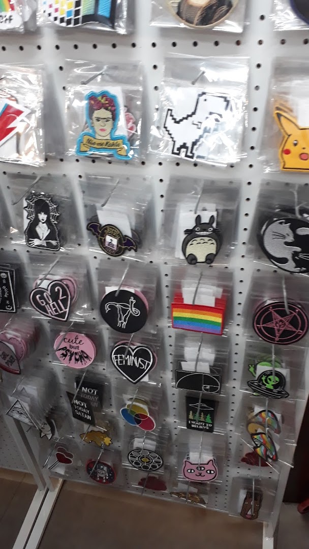 A wall display of various novelty patches and pins, featuring pop culture and feminist designs.