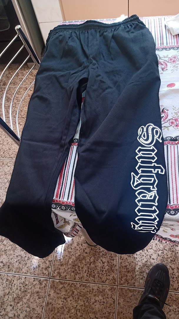 Black sweatpants with white gothic lettering on the side.