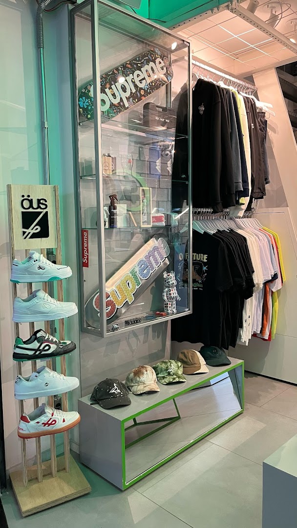 A retail store display featuring sneakers, skateboards, apparel, and hats.