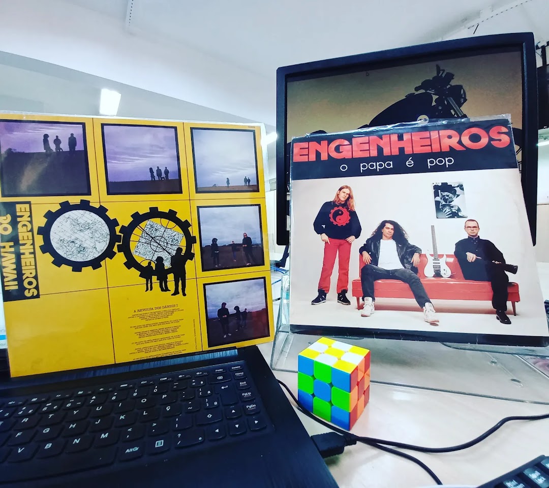 Two vinyl records, one yellow with multiple images and text, the other with a band photo and text.